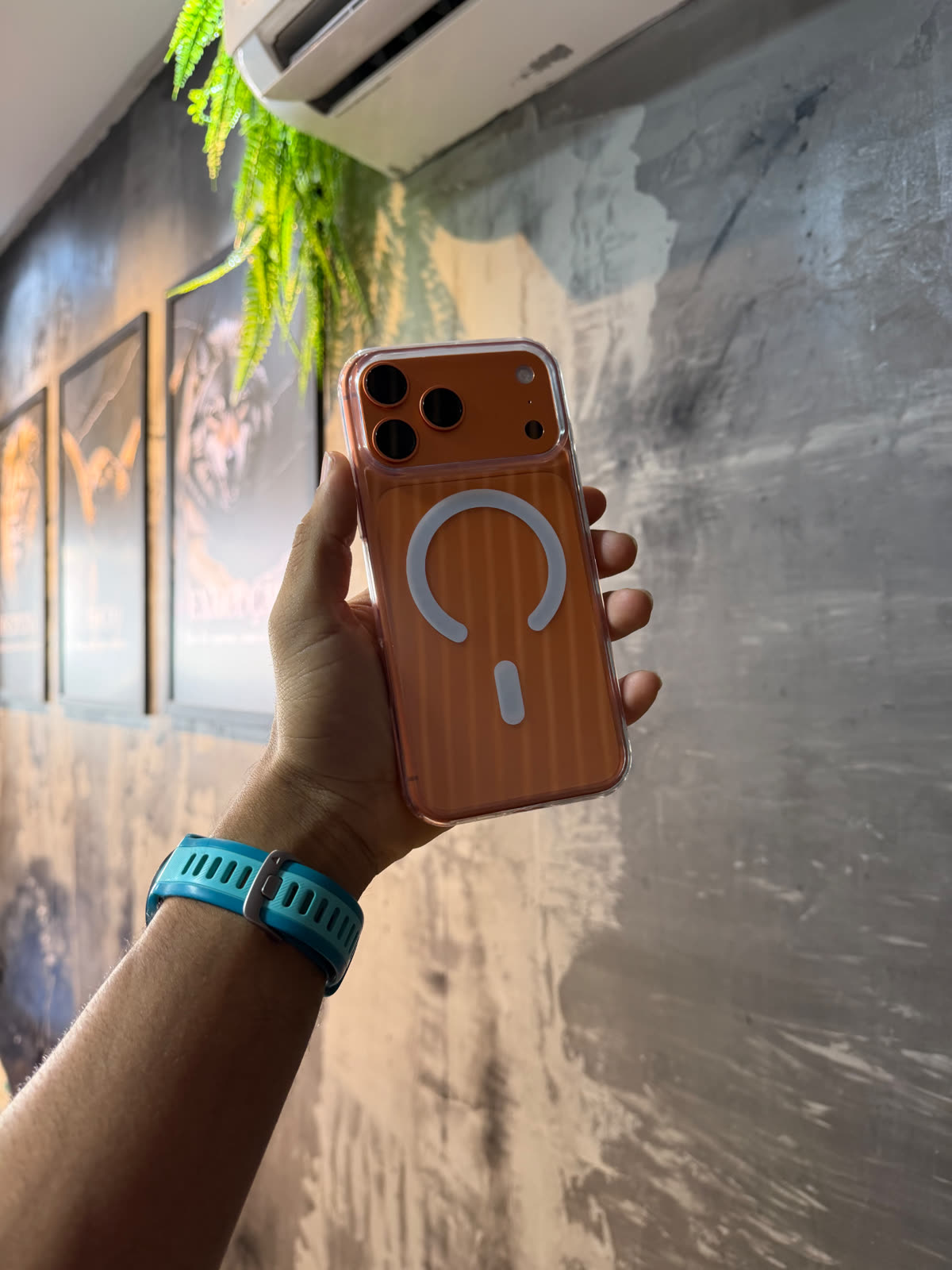 iPhone laranja em mãos dentro da loja TECHCEL