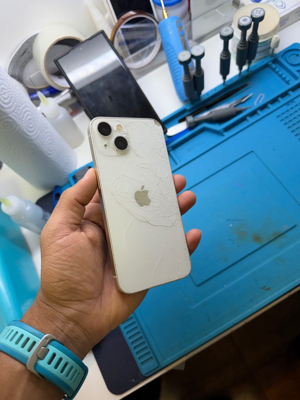 iPhone branco com a tampa de vidro traseira totalmente trincada, antes do reparo na TECHCEL